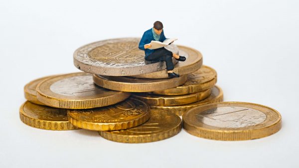 Osoba siedząca na stosie monet